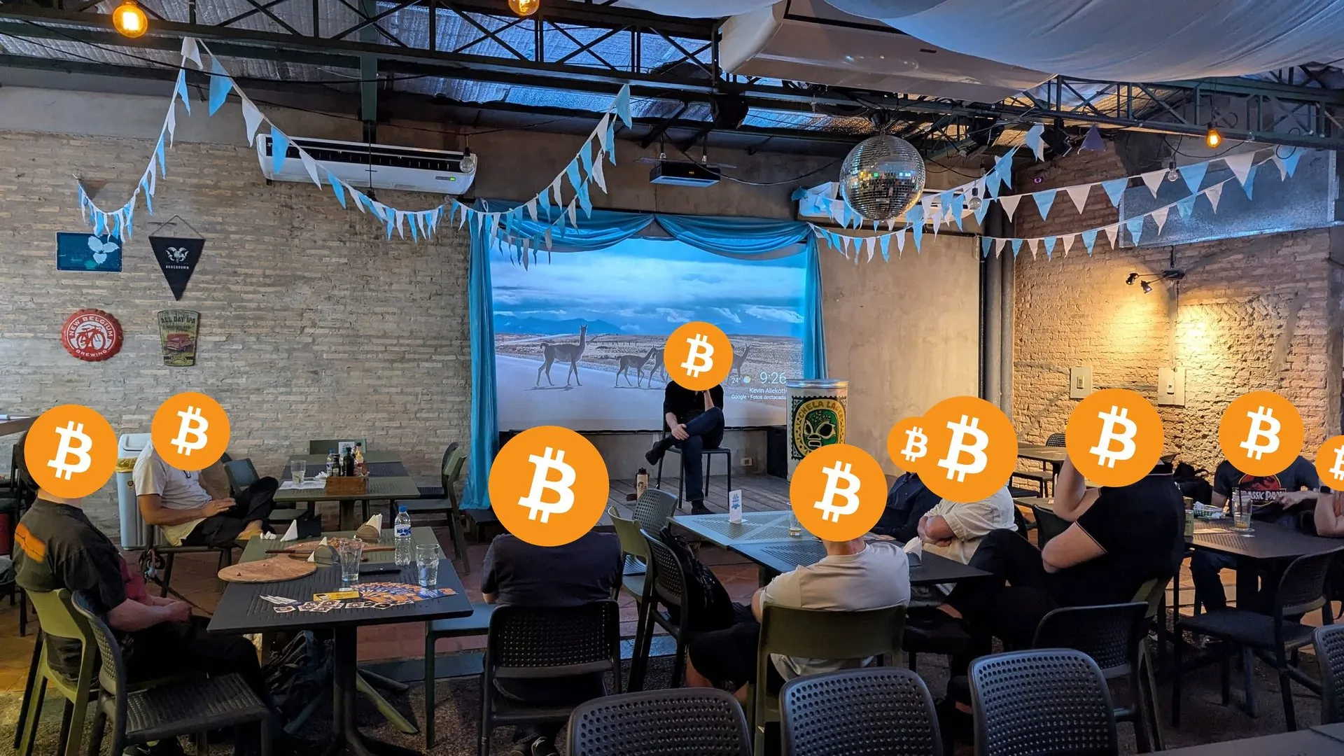 Charla en un bar de ladrillo visto, con banderines celestes y blancos